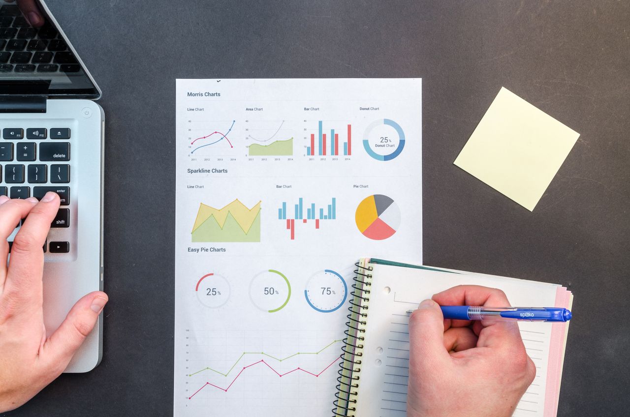 Services Hands interacting with charts and notes for data analysis on a desk.